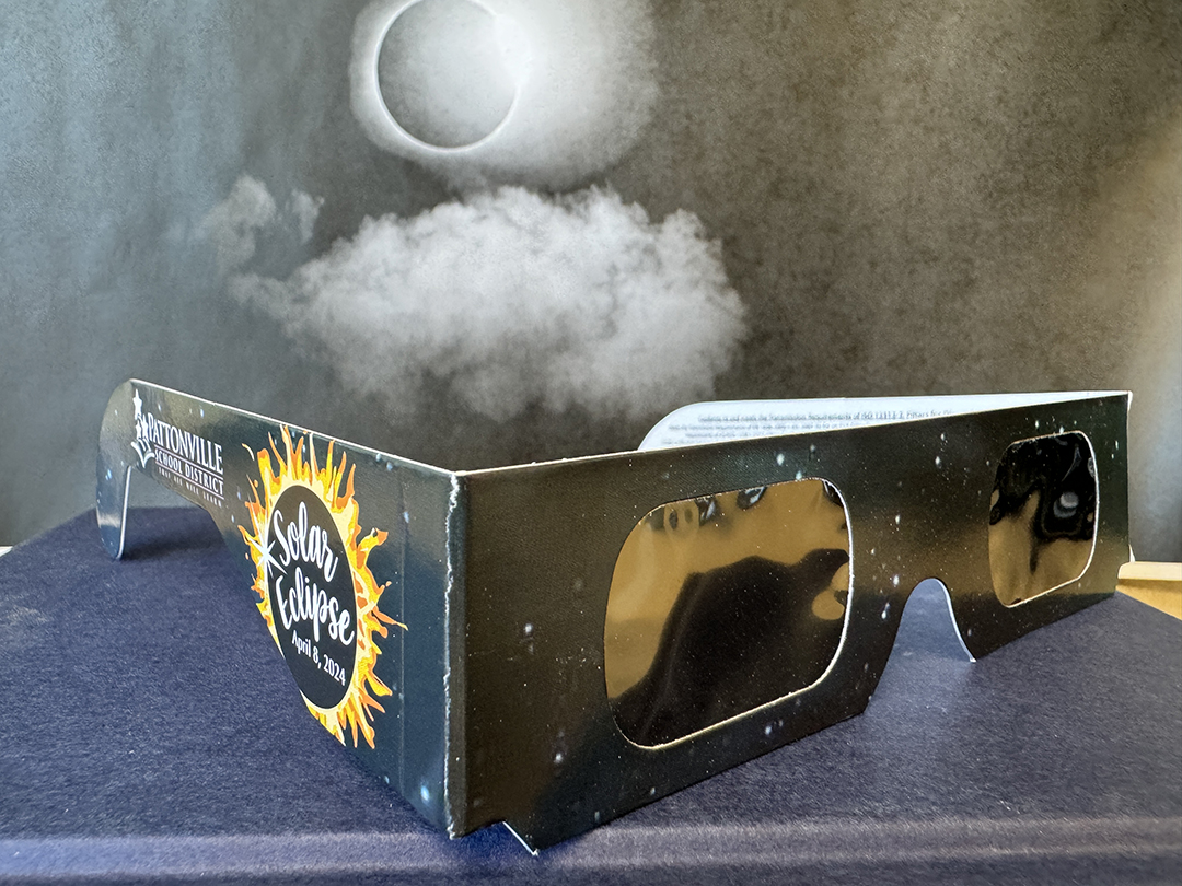 Eclipse glasses with picture of 2017 eclipse in background